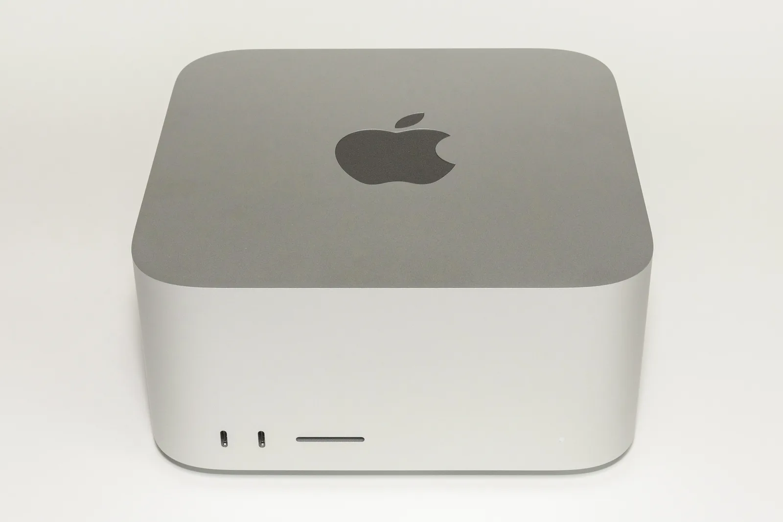 Un computer Mac Studio argintiu (model 2022), fotografiat din față pe fundal alb