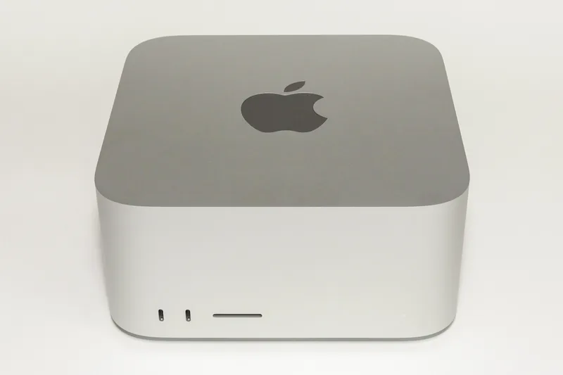Un computer Mac Studio argintiu (model 2022), fotografiat din față pe fundal alb